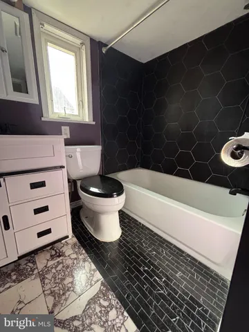 a bath room with a toilet and a bath tub