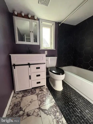 a bathroom with a toilet and a mirror