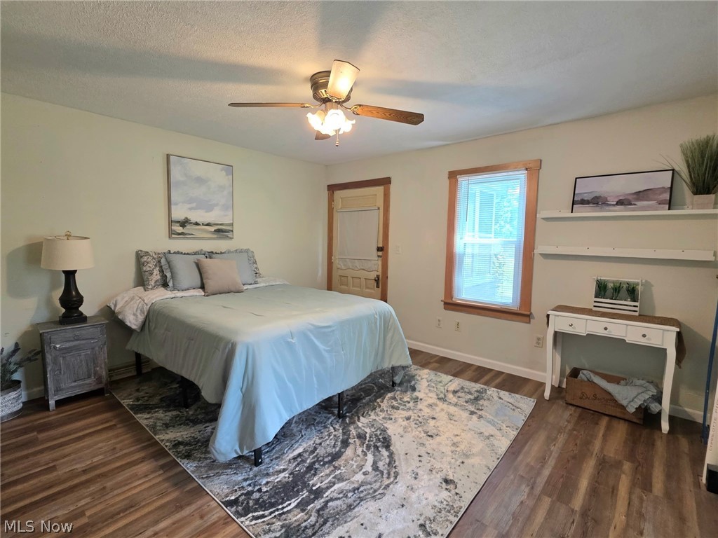 2335 West River Road Newton Falls, OH 44444 - Photo 15 of 36 Spacious room featuring wood-finish flooring, a ceiling fan with light fixture, and a window with wood trim