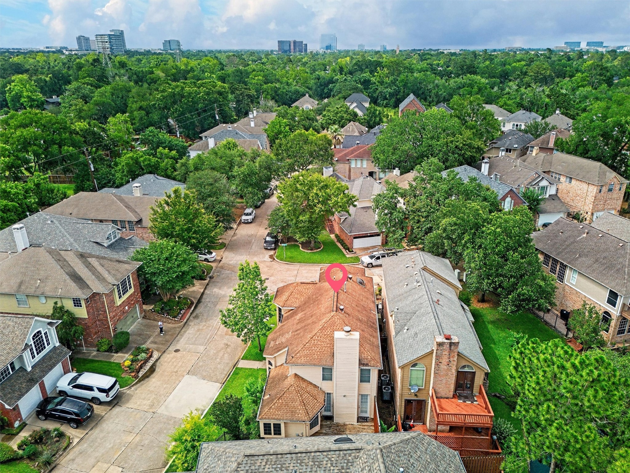 12929 Kingsbridge Lane Houston, TX 77077 - Photo 37 of 42 Beautiful aerial view showcasing this home’s prime location nestled within a mature tree-lined neighborhood with stunning city skyline views in the distance. Buyers will love the peaceful community feel, established surroundings, and convenient access to major shopping, dining, entertainment, and commuter routes. Located in a highly desirable area with beautiful homes and lush greenery throughout, this property offers the perfect blend of privacy, accessibility, and lifestyle.