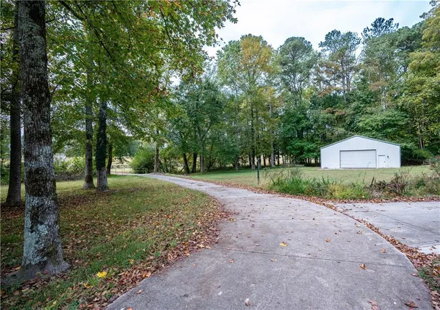 a front view of a house with a yard and trees