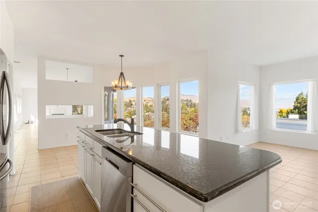 a kitchen with stainless steel appliances granite countertop a sink a stove and a refrigerator