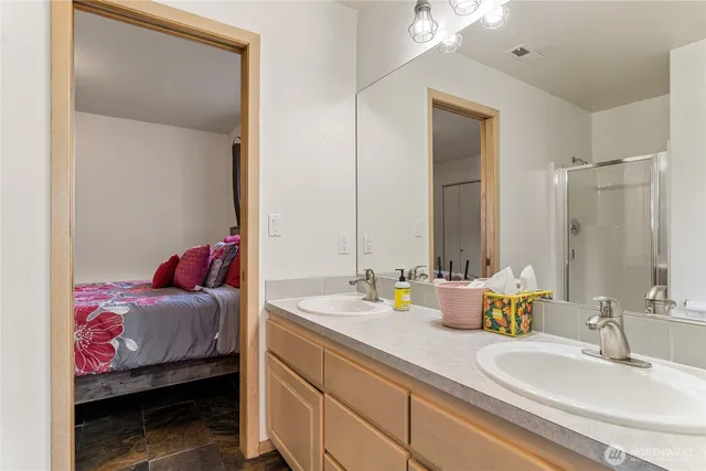 a en suite bathroom with a double vanity sink and a mirror