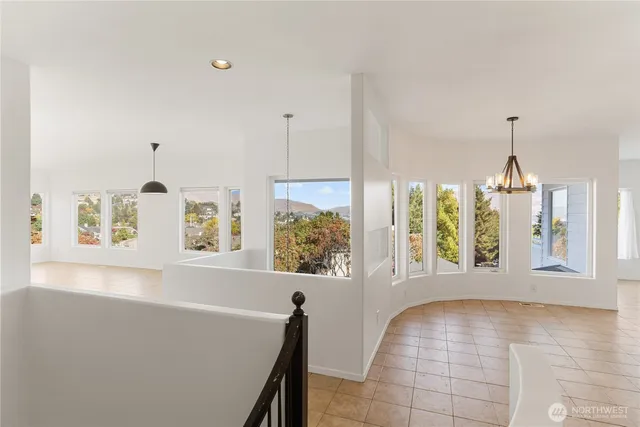 a view of an empty room with window and chandelier