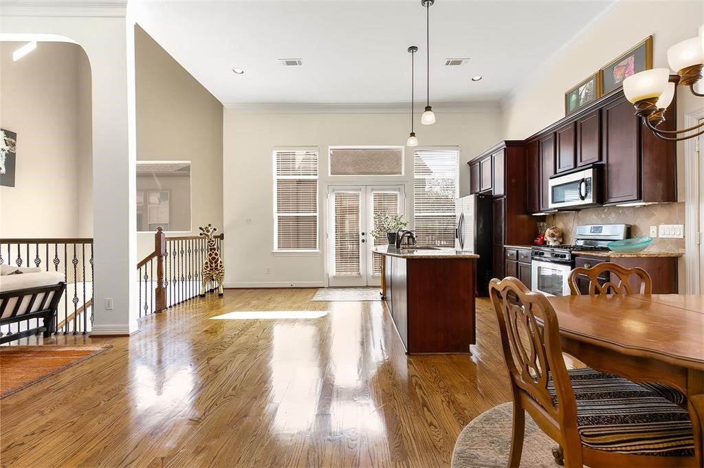 4316 Eli Street Houston, TX 77007 - Photo 5 of 20 a dining room with wooden floor a chandelier a glass table and chairs