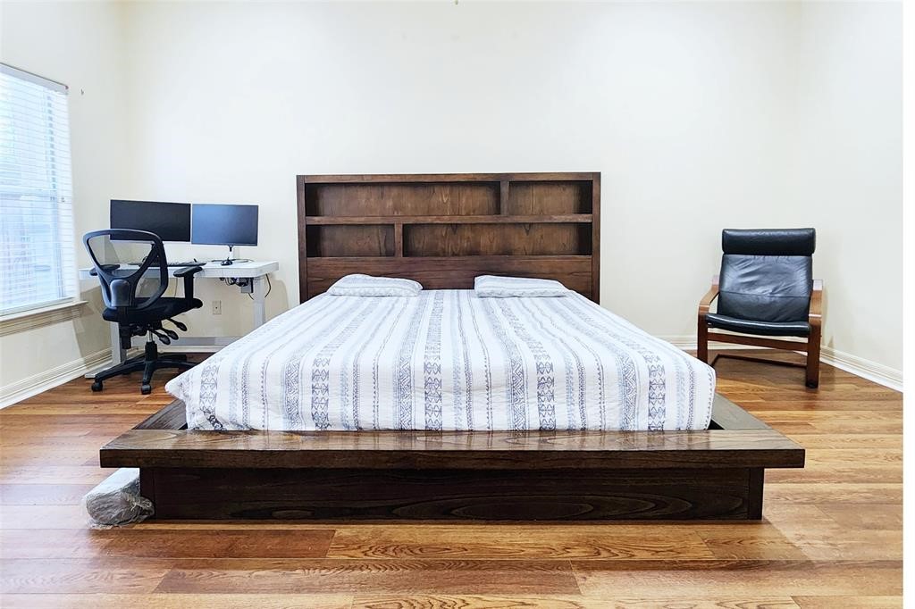 4316 Eli Street Houston, TX 77007 - Photo 8 of 20 a bed sitting in a bedroom next to a table with chair