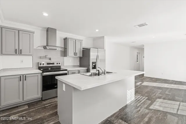 a kitchen with a sink a stove a refrigerator and white cabinets