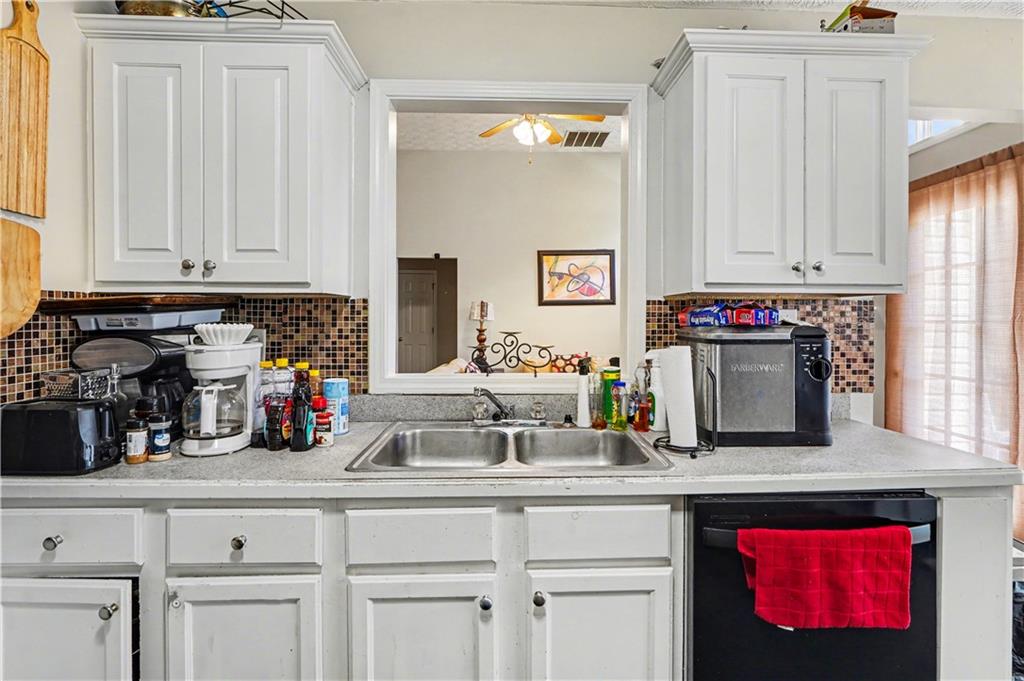 176 Shoreline Way Hampton, GA 30228 - Photo 11 of 32 a kitchen with white cabinets and a window