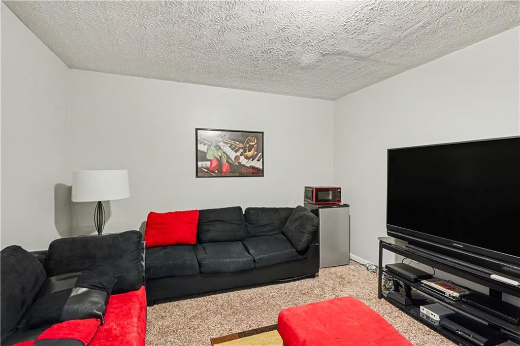 176 Shoreline Way Hampton, GA 30228 - Photo 23 of 32 a living room with furniture and a flat screen tv
