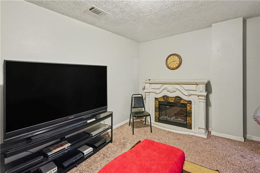 176 Shoreline Way Hampton, GA 30228 - Photo 24 of 32 a living room with furniture and a flat screen tv