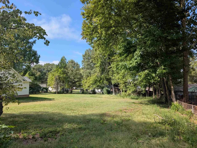 a view of a field with trees in the background