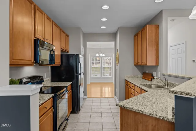 a large kitchen with granite countertop a sink and cabinets