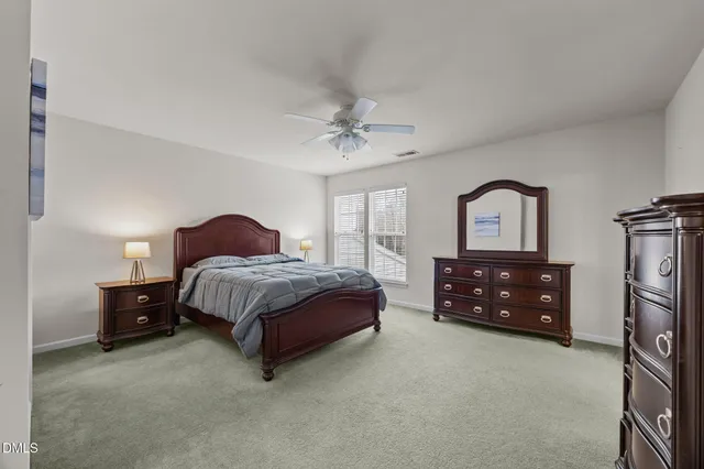 a bedroom with a bed dresser and a window