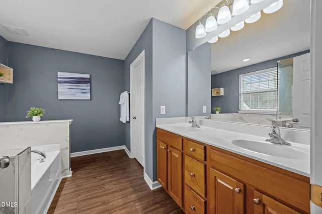 a bathroom with a tub a sink and a window