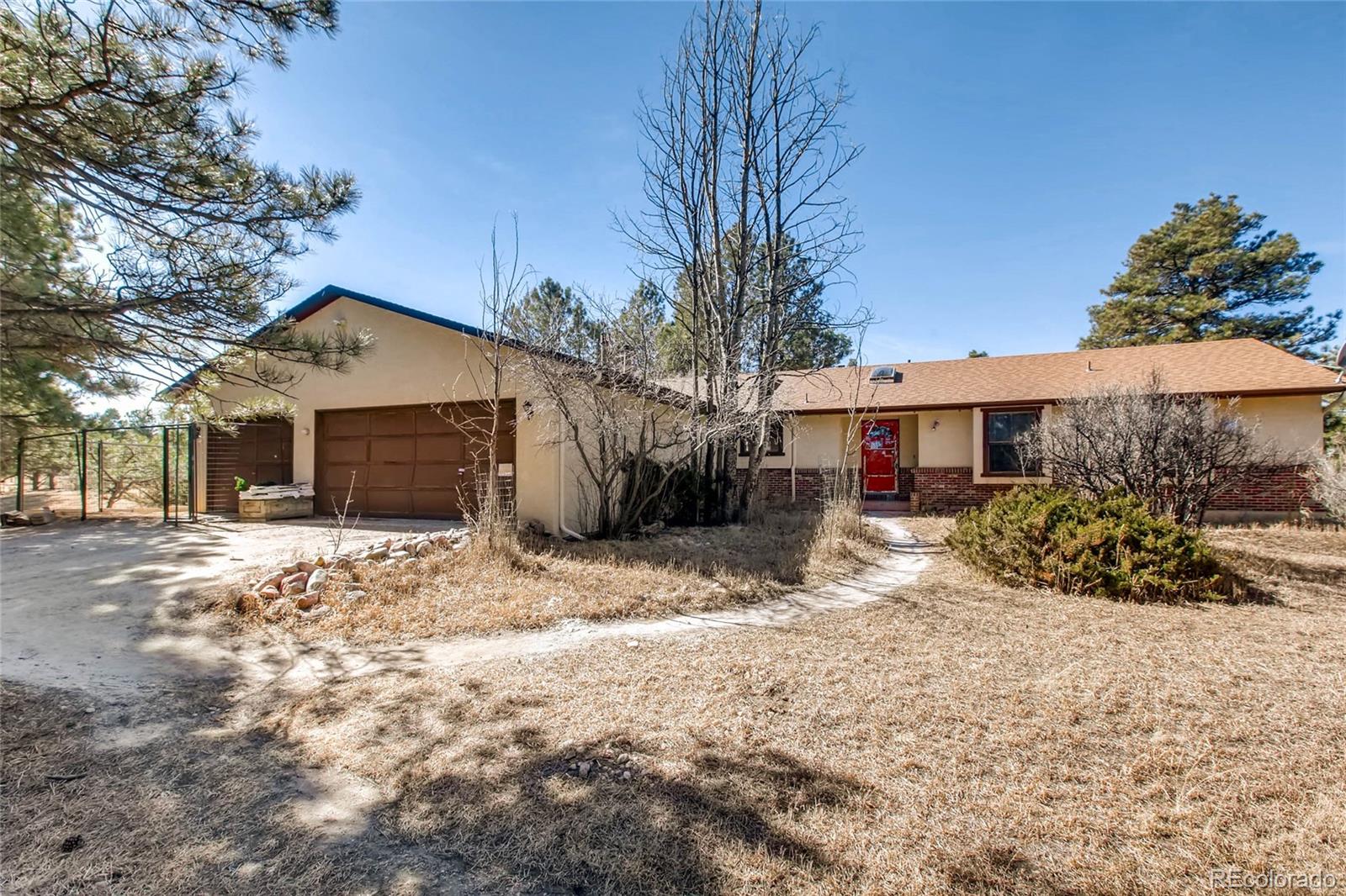18755 Ranch Hand Road Peyton, CO 80831 - Photo 1 of 27 a front view of a house with a yard and garage