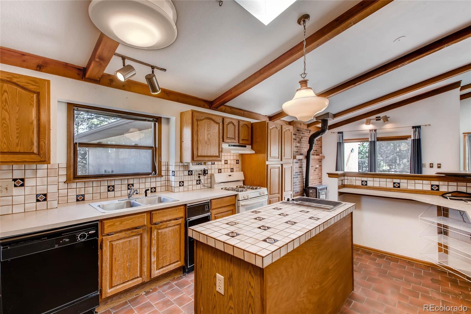 18755 Ranch Hand Road Peyton, CO 80831 - Photo 11 of 27 a kitchen with a stove a sink dishwasher and a refrigerator with wooden floor