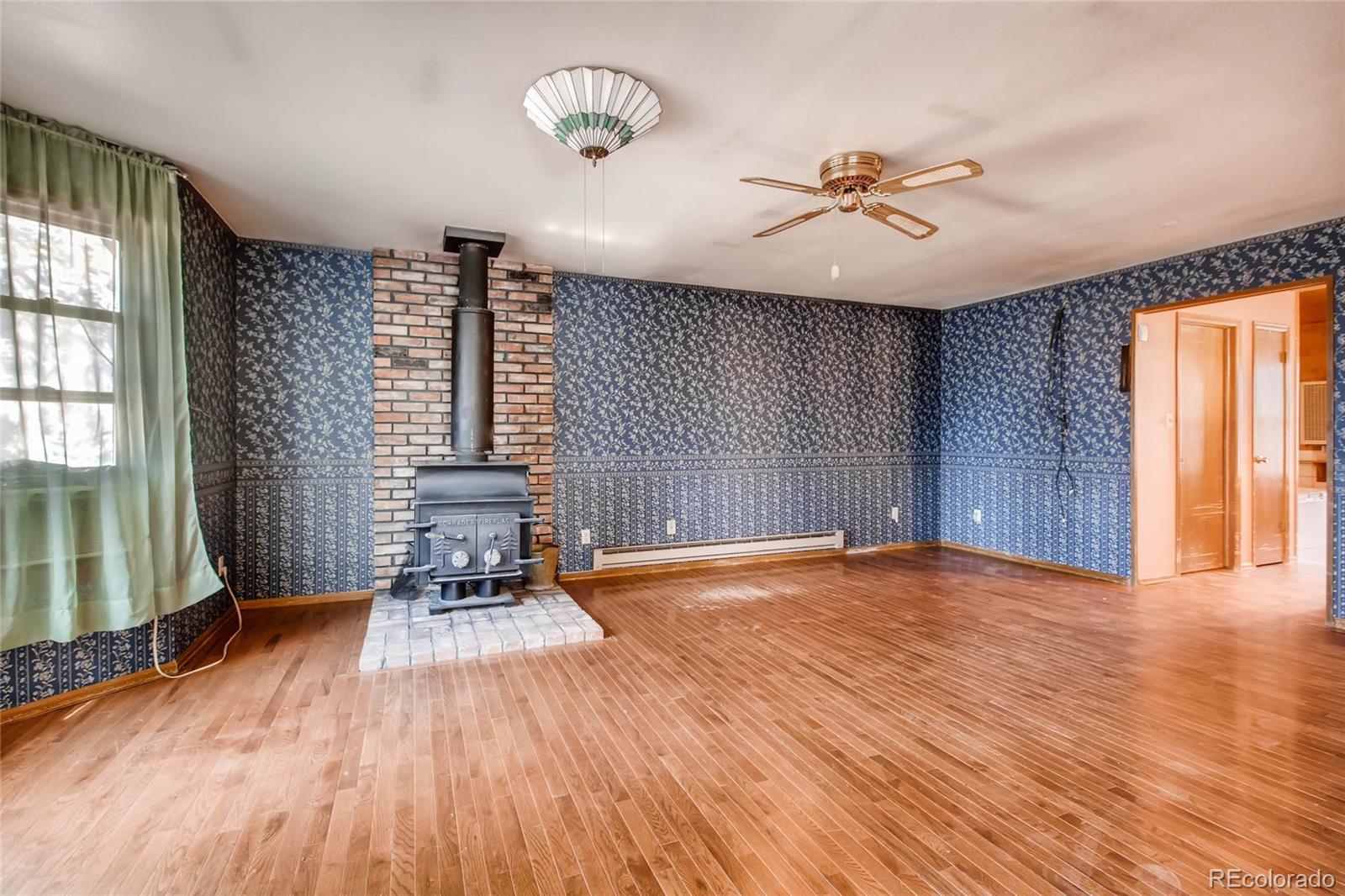 18755 Ranch Hand Road Peyton, CO 80831 - Photo 14 of 27 a view of an empty room with a window and wooden floor