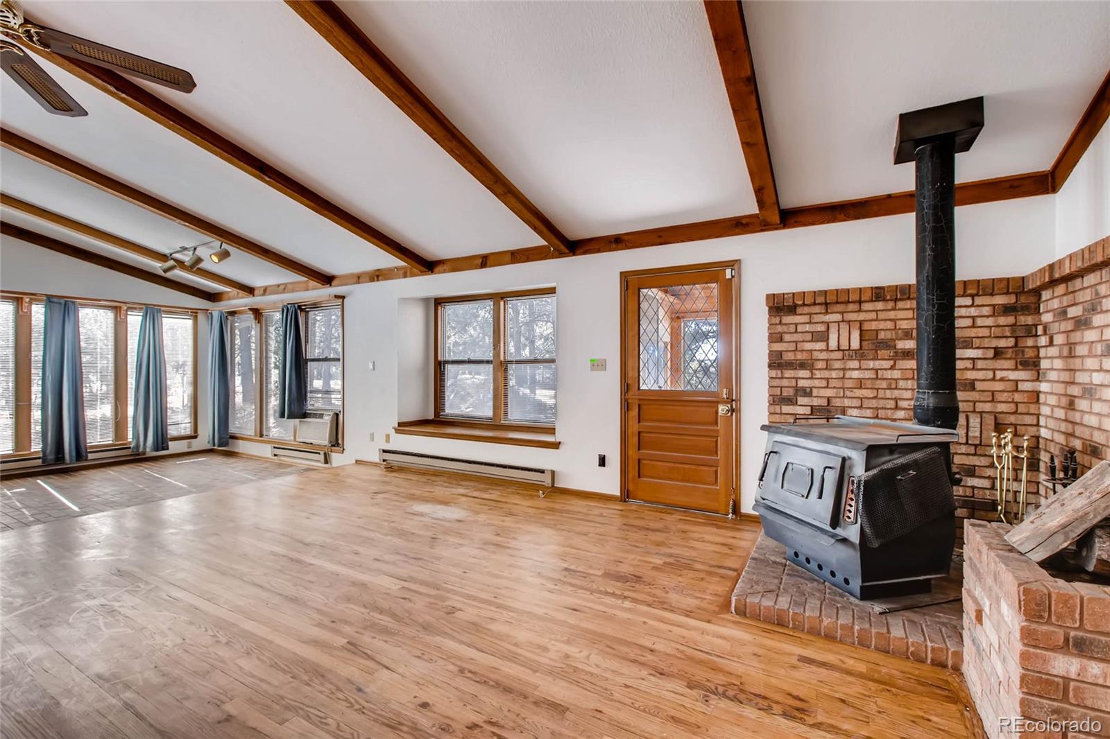 18755 Ranch Hand Road Peyton, CO 80831 - Photo 4 of 27 a view of an empty room with wooden floor and windows
