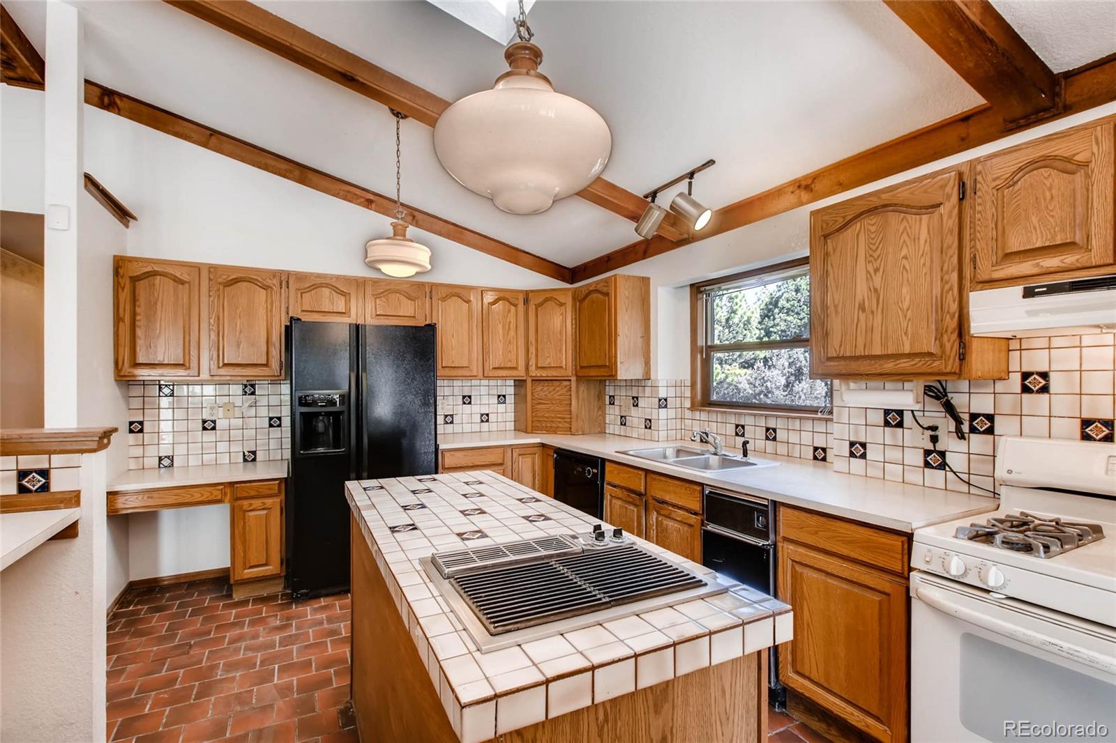 18755 Ranch Hand Road Peyton, CO 80831 - Photo 10 of 27 a kitchen with a sink a stove a refrigerator and cabinets