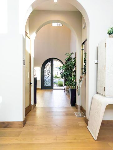 a view of a hallway with wooden floor and a bathroom