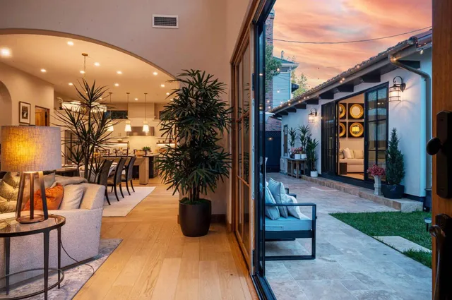 a living room with furniture a chandelier and a flat screen tv