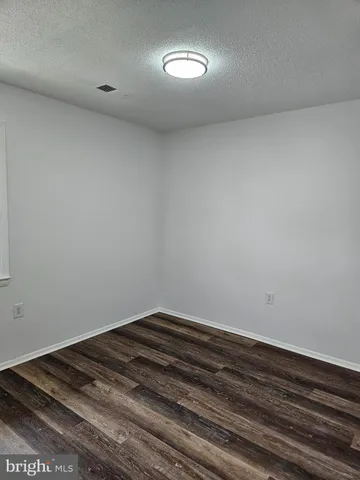 an empty room with wooden floor and closet