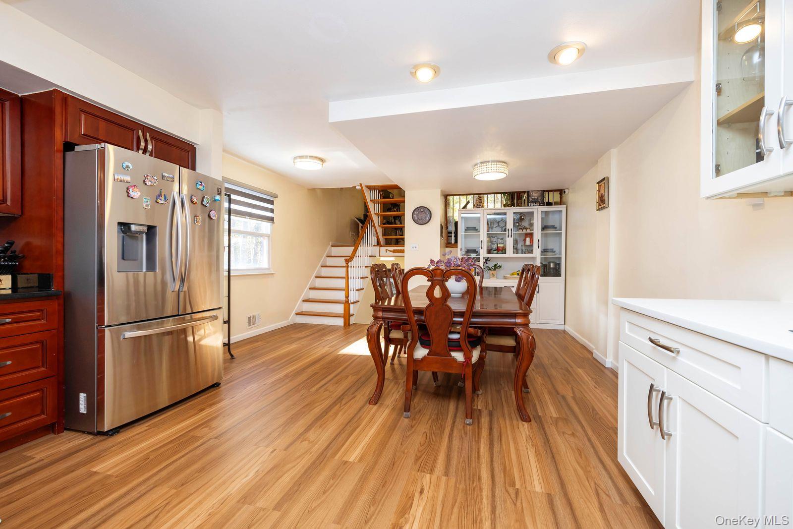 197 Park Drive North Staten Island, NY 10314 - Photo 11 of 37 a kitchen with stainless steel appliances granite countertop a refrigerator a stove a sink dishwasher and a dining table with wooden floor