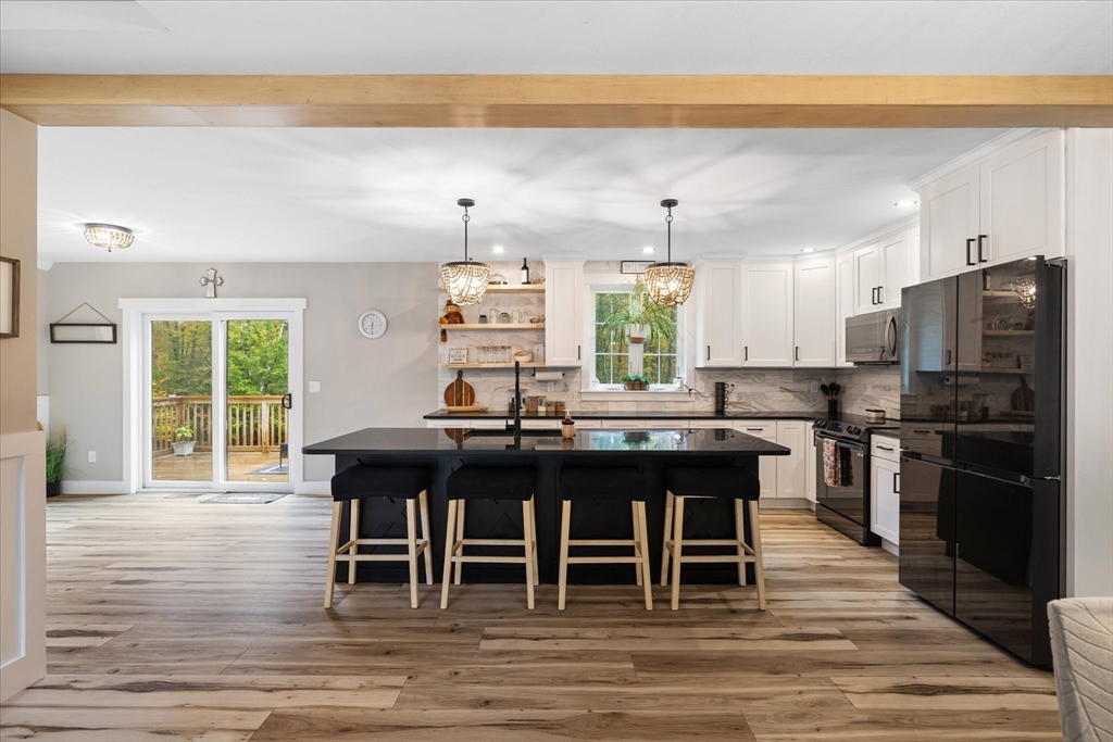 1015 Willis Road Phillipston, MA 01331 - Photo 14 of 42 a kitchen with stainless steel appliances kitchen island granite countertop a table chairs sink and cabinets
