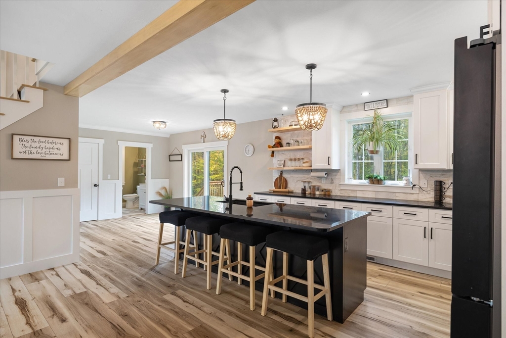 1015 Willis Road Phillipston, MA 01331 - Photo 16 of 42 a kitchen with stainless steel appliances granite countertop a stove a sink dishwasher a dining table and chairs with wooden floor