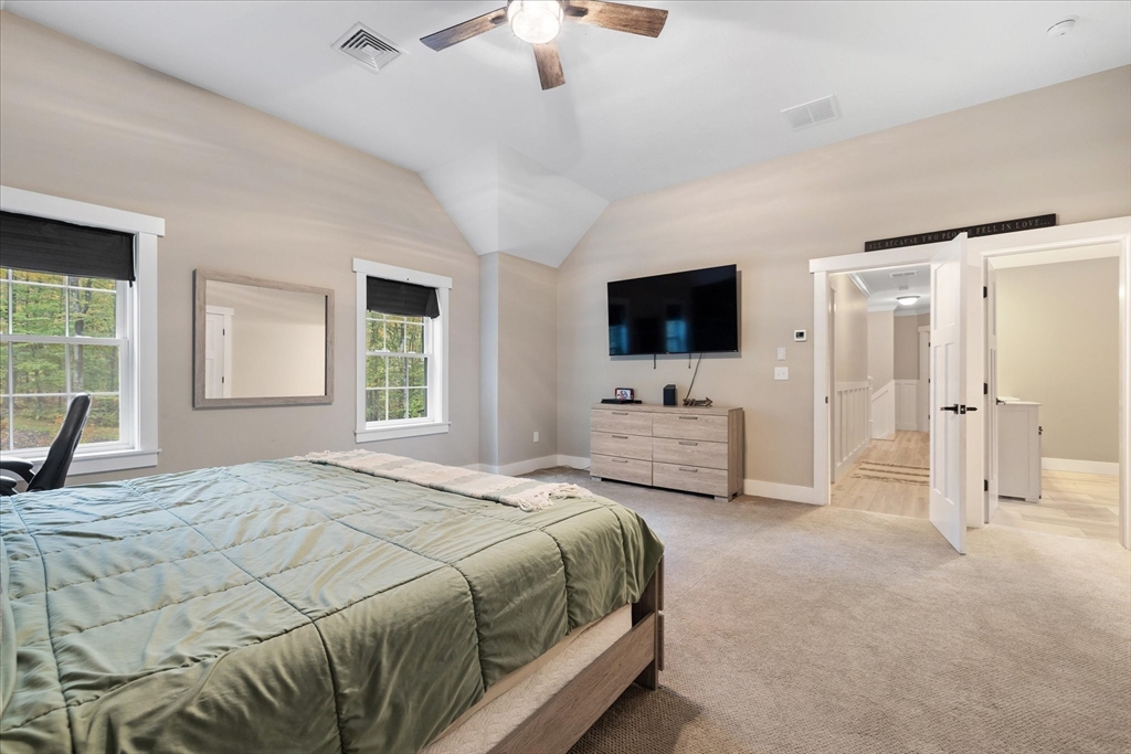 1015 Willis Road Phillipston, MA 01331 - Photo 25 of 42 a spacious bedroom with a bed a flat screen tv and windows