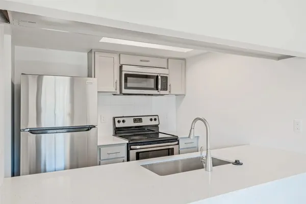 a kitchen with a refrigerator and a stove top oven