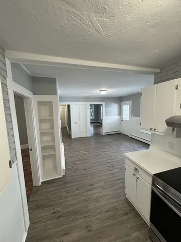 a kitchen with cabinets and wooden floor