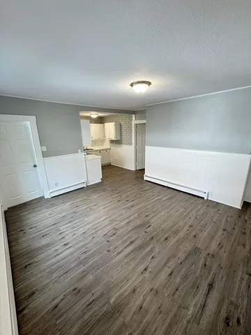 an empty room with wooden floor and window