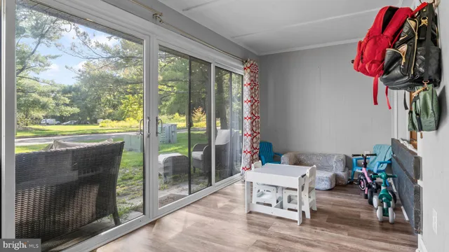a living room with furniture a floor to ceiling window and a flat screen tv