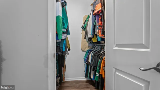a view of walk in closet with clothes and shoes