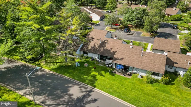 an aerial view of residential house with outdoor space and trees all around