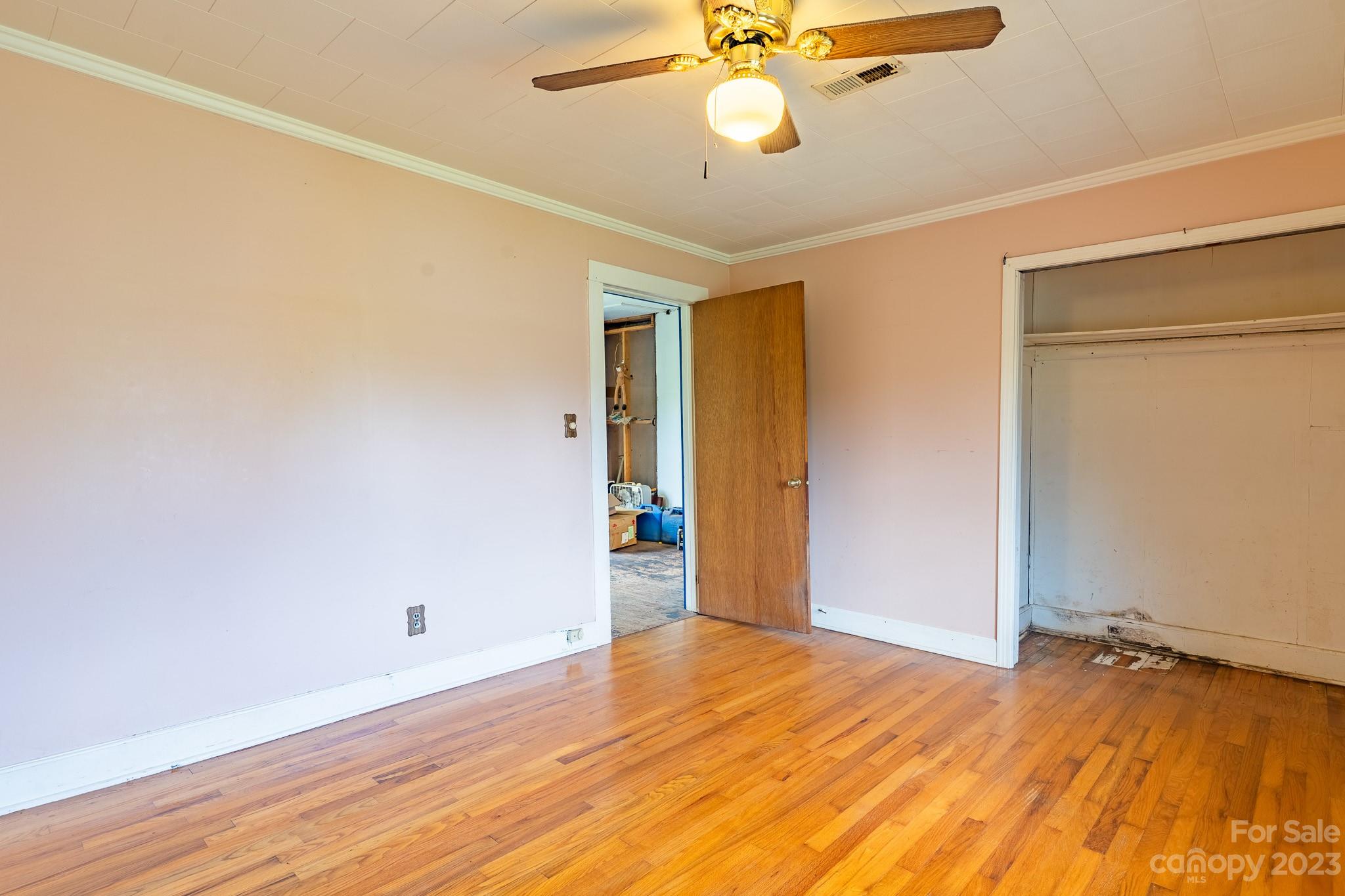 146 Sorrells Road Rutherfordton, NC 28139 - Photo 13 of 25 an empty room with wooden floor and fan