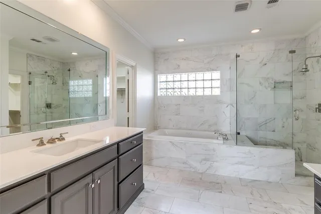 a bathroom with a sink double vanity granite tub shower and a mirror
