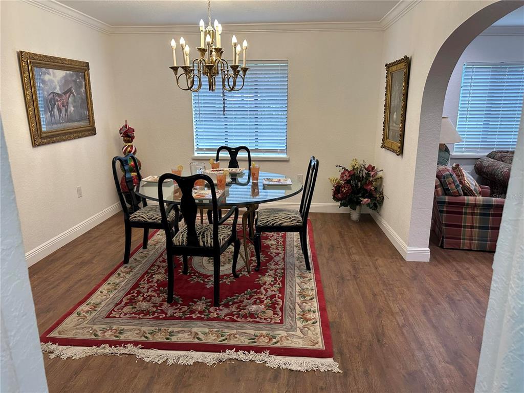 17067 Northwest Gainesville Road Reddick, FL 32686 - Photo 4 of 25 a view of a dining room with furniture wooden floor and a chandelier