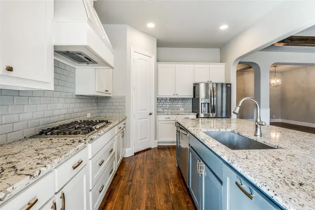 a kitchen with stainless steel appliances granite countertop a sink stove and cabinets