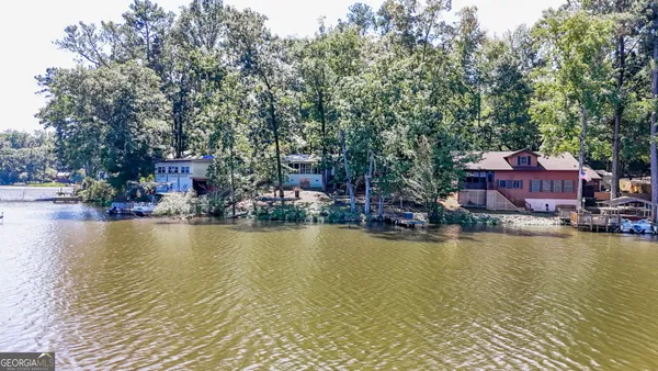 an aerial view of residential houses with outdoor space and trees