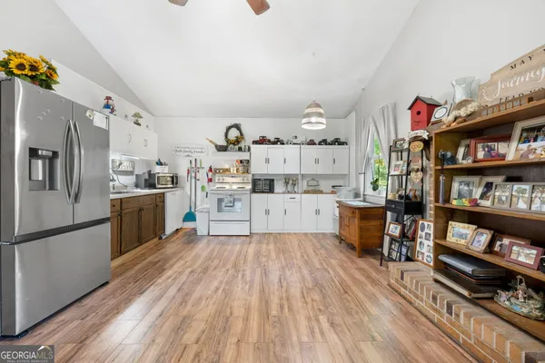a kitchen with a refrigerator and a stove top oven