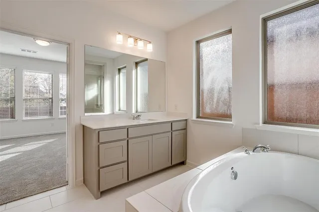 a bathroom with a tub sink and mirror