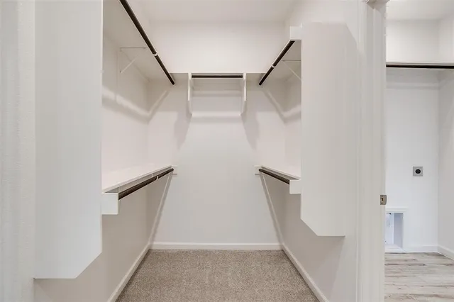 a view of walk in closet with empty racks