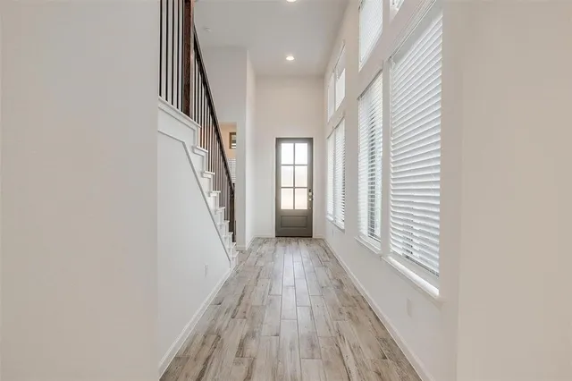 a view of a hallway with wooden floor and staircase