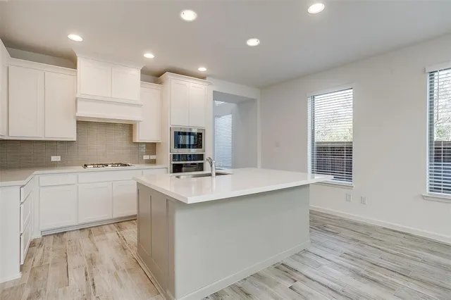 a kitchen with appliances a sink and cabinets