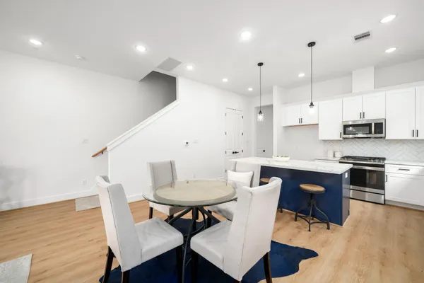 a kitchen with a dining table chairs and white cabinets