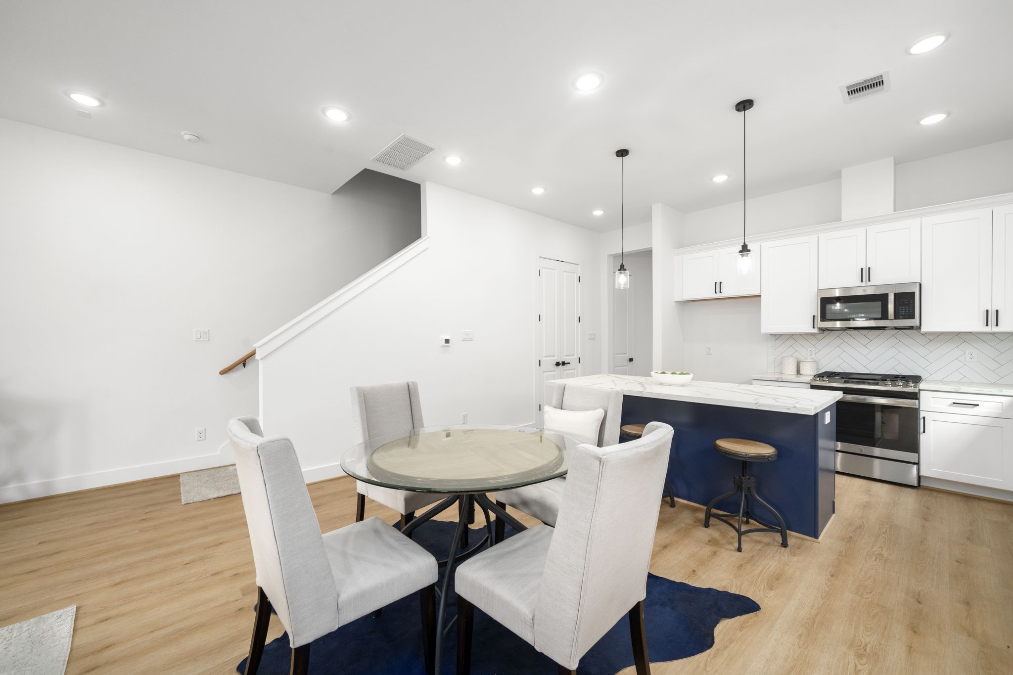 5514 Hardy Street Houston, TX 77009 - Photo 10 of 30 a kitchen with a dining table chairs and white cabinets