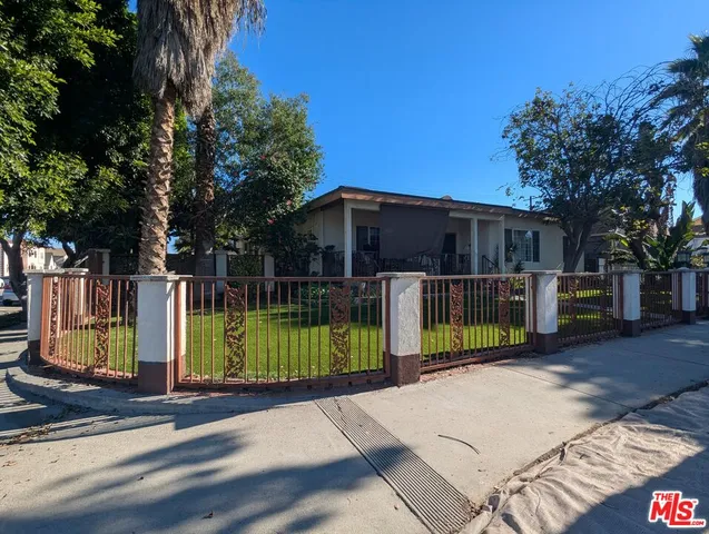a view of a house with backyard and wooden fence
