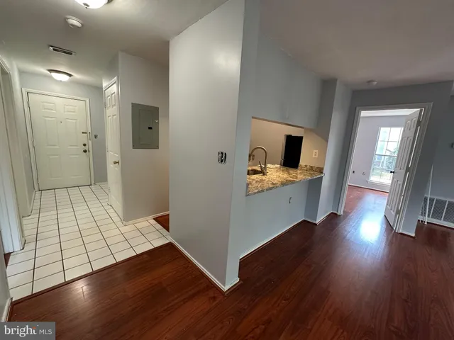 a view of a hallway with wooden floor and furniture